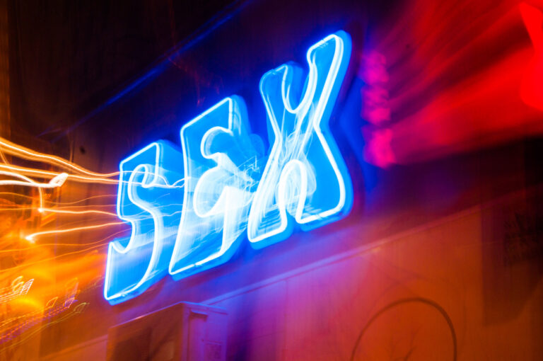Sex sign. Blue neon color, zoomburst effect obtained zoom in and out the sign to obtain a graphical motion content.