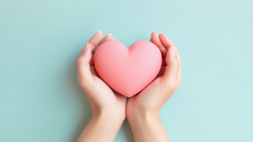 Woman hands holding pink heart.