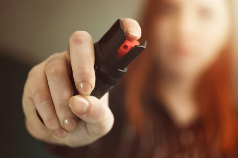 A woman holding pepper spray