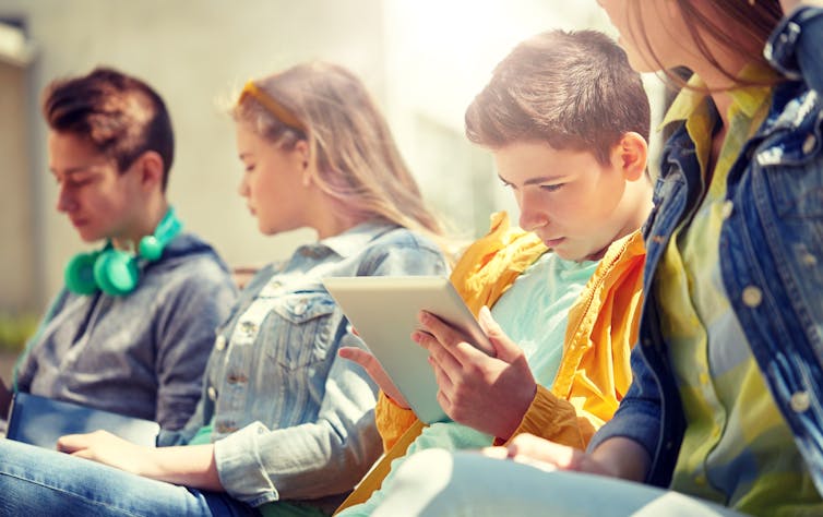 Boy looks at phone. Image: Shutterstock
